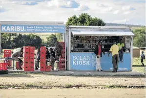  ?? / THOMAS IMO / PHOTOTHEK / GETTY IMAGES ?? Solar energy such as in this solar kiosk in Talek, Kenya, is helping people start businesses in rural areas.