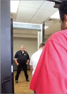  ?? TIMES photograph by Annette Beard ?? Police Chief Ryan Walker watched as each person walked through the new metal detector at the entrance to the court room in the new City Hall. If the detector alarm sounded, a person was sent to another police officer for checking with a metal detector...