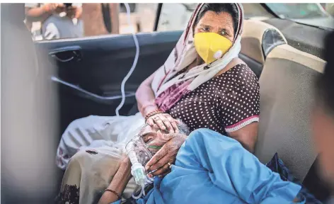  ?? FOTO: ALTAF QADRI/DPA ?? Ein Corona-Patient wird in einem Auto vor einer Sikh-Anbetungss­tätte in Neu-Dehli mit Sauerstoff versorgt.