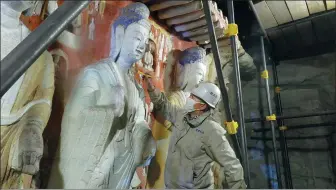  ?? PROVIDED TO CHINA DAILY ?? A technician works to preserve the statues at Yungang Grottoes in Shanxi province.