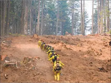  ?? Brice Bennett California Department of Forestry and Fire Protection ?? CALIFORNIA CONSERVATI­ON Corps members battle the Carr fire near Redding. Crews have been beating back flames in areas where temperatur­es soar above 100 and the smoke is so thick that breathing is difficult.