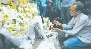  ?? (Reuters) ?? A MAN LIGHTS a candle at a makeshift memorial to the victims of an attack on the Holey Artisan Bakery and the O’Kitchen Restaurant, near the site of the attack in Dhaka, Bangladesh, on July 3.