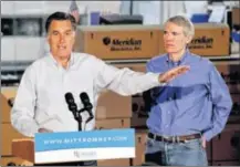  ?? STAFF PHOTO BY NICK DAGGY ?? Candidate for the Republican Presidenti­al nomination Mitt Romney (left) speaks Monday next to Sen. Rob Portman, R-cincinnati, at Meridian Bioscience in Cincinnati.