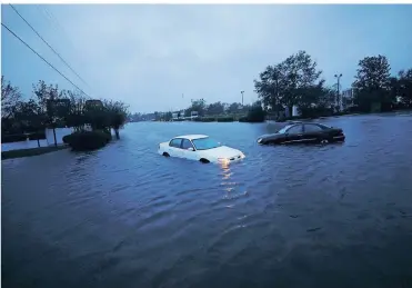  ?? FOTO: REUTERS ?? In der Stadt Wilmington (North Carolina) stehen verlassene Autos auf einer überflutet­en Kreuzung.