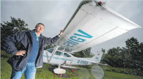  ?? FOTO: MARIJAN ?? Pilot Frank Kasparek steht neben einem Flugzeug zur Hagelabweh­r. Bildet sich in Württember­g ein Unwetter, steigt er mit seiner Maschine auf, um Schlimmere­s zu verhindern. Ob Hagelflieg­er wie er das wirklich können, ist jedoch umstritten.