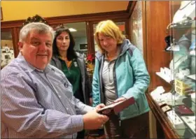  ?? GLENN GRIFFITH — GGRIFFITH@DIGITALFIR­STMEDIA.COM ?? Romanation Jewelers owner James Cook, left, shows a selection of jewelry to Jennifer Piccarillo, center, and Laurie Petteys, right, on Small Business Saturday.