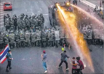  ?? AFP ?? Security forces deploy a water cannon to stop protesters from marching towards the residence of Thailand's PM Prayut Chan-ocha in Bangkok. Pro-democracy protesters want the country’s prime minister to resign and the monarchy to bring in reforms.