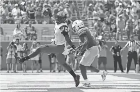  ?? TIM WARNER / GETTY IMAGES ?? Maryland’s Kasim Hill (11) rushes for a touchdown past Texas’ DeShon Elliott (4) on Saturday at Darrell K Royal-Texas Memorial Stadium in Austin, Texas.