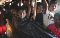  ?? (Damir Sagolj/Reuters) ?? ROHINGYA CHILDREN look on as 11-month-old Abdul Aziz is brought back to his family’s shelter on Monday at the Balukhali refugee camp near Cox’s Bazar, Bangladesh, a few hours after he died. According to his mother, the boy suffered from high fever and...