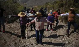  ??  ?? Relatives of the disappeare­d form a human chain to comb a suspected clandestin­e burial ground in the Mexican town of Ensenada last month. Photograph: Emilio Espejel/The Guardian