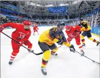  ?? AP PHOTO/JOHN LOCHER ?? Marcel Goc (57), of Germany, battles for the puck between Russian athletes Vyacheslav Voynov (26) and Pavel Datsyuk (13) during the second period of the men’s gold medal hockey game at the 2018 Winter Olympics, Sunday in South Korea.