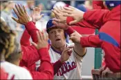  ?? GETTY IMAGES ?? Rhys Hoskins high-fives his Phillies teammates in the dugout after scoring a run. Hoskins has continued his emergence as a superstar after belting 17 home runs in 170 at-bats last season.