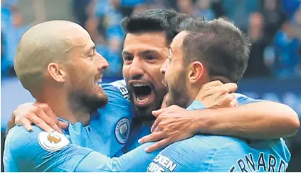  ?? Picture: AFP ?? TRIPLE THREAT. Manchester City’s Sergio Aguero (centre) celebrates with team-mates David Silva and Bernardo Silva after scoring against Huddersfie­ld Town at the Etihad yesterday.