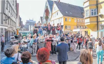  ?? FOTO: THOMAS SIEDLER ?? Mit einem Flashmob mitten auf dem Wochenmark­t hat der 1. Aalener Bürgerchor auf die Premiere des Stücks „Wir sind die nebelfreie Stadt“aufmerksam gemacht, das am 4. Mai in der Aalener Stadthalle zu erleben ist.