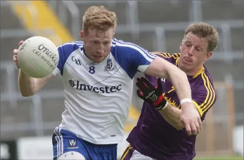  ??  ?? Powerful Monaghan midfielder Kieran Hughes brushing aside the challenge of Wexford defender Tiarnan Rossiter.