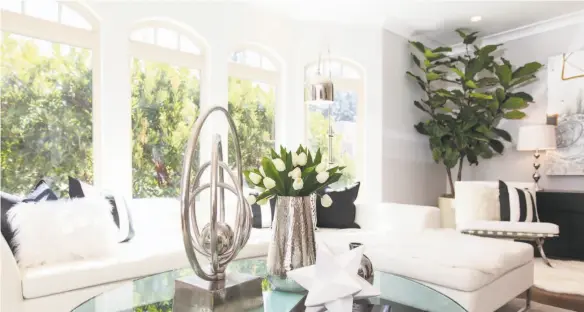  ?? Photos by Open Homes Photograph­y ?? Above: A series of tall arched windows welcomes sunlight into the living room at 2526 Francisco St. in the Marina district. Below left: This tile deck off the living room offers a spot for grilling and outdoor dining. Below right: The master suite’s...