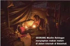  ??  ?? SEORANG Muslim Rohingya menyiapkan makan malam di dalam khemah di Balukhali.
