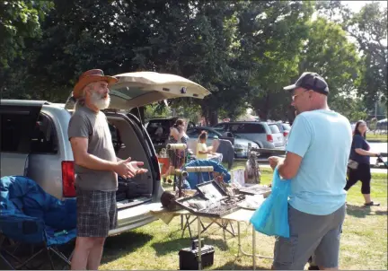  ?? TYLER RIGG — THE NEWS-HERALD ?? Visitors speak with a vendor at the Osborne Park Market & Flea in Willoughby, July 31.