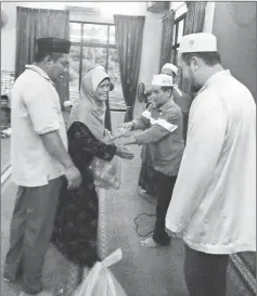  ??  ?? Butir (second right) presents the donation to a villager during the PAS programme at Kampung Sungai Rait.