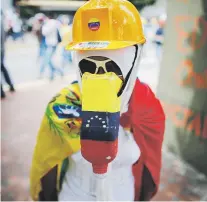  ??  ?? Arriba, una mujer se protege con un casco, lentes y una botella de plástico a manera de máscara antigás; abajo, una variedad de escudos caseros.