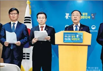  ?? European Pressphoto Agency ?? HONG NAM-KI, right, South Korea’s minister for government policy coordinati­on, announces at a meeting in Sejong the introducti­on of a real-name transactio­n system for cryptocurr­ency trading.