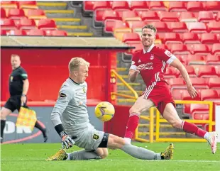  ??  ?? Dons debutant Marley Watkins is denied by Livi’s Robby Mccrorie. SNS.