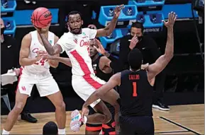  ?? DARRON CUMMINGS / AP ?? Houston guard DeJon Jarreau (3) passes over Oregon State forward Maurice Calloo (1) during the first half of an Elite 8 game in the NCAA men’s college basketball tournament at Lucas Oil Stadium Monday in Indianapol­is.