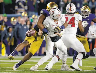  ?? Michael Hickey / Getty Images ?? Stanford quarterbac­k K.J. Costello is hit by Notre Dame’s Jerry Tillery, who had four sacks in the game.