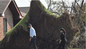  ?? MANDEL NGAN/AFP VIA GETTY IMAGES ?? President Joe Biden walks by a tree uprooted during hurricane Ida during a visit to a neighborho­od in LaPlace, La., on Friday.