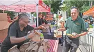  ?? MICHAEL SEARS / MILWAUKEE JOURNAL SENTINEL ?? Kurt Gorski of the City of Milwaukee Department of Neighborho­od Services gets a free sub and chips from Cousins Subs then picks up a free salad from Rayshawn Ward (left) of Davians during the 12th Annual Downtown Employee Appreciati­on Week.