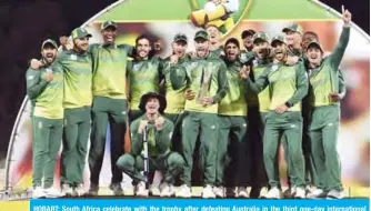  ??  ?? HOBART: South Africa celebrate with the trophy after defeating Australia in the third one-day internatio­nal cricket match to take the series 2-1 in Hobart yesterday. —AFP