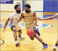  ?? Christian Abraham / Hearst Connecticu­t Media ?? Notre Dame-Fairfield’s GariVonni Bennett drives to the basket between two Kolbe Cathedral defenders during the SWC championsh­ip in Brookfield in March.