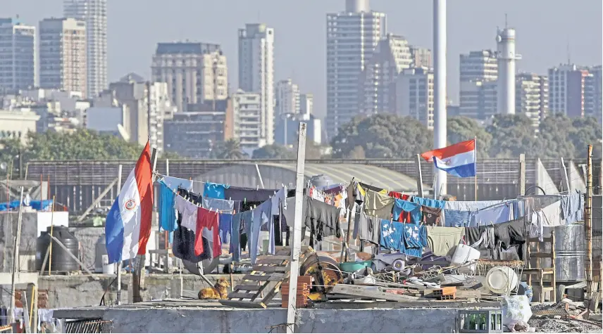  ??  ?? Retiro. Banderas de Paraguay flamean en la villa 31, donde la comunidad de ese país es la más numerosa; en la ciudad de Buenos Aires y en el conurbano se concentra la mayor parte de los inmigrante­s