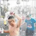  ?? Marcus Yam Los Angeles Times ?? TAKE ADVANTAGE of the water at aid stations along the route, as these 2015 runners did in Beverly Hills.