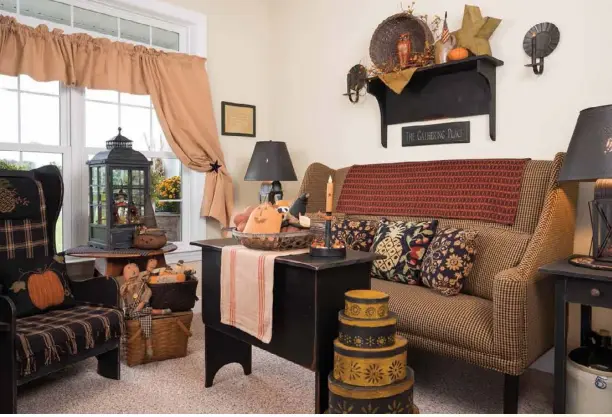  ??  ?? Featuring a pleasing mix of antiques and carefully chosen reproducti­ons, the cozy sitting room shows off Julie’s ability to successful­ly mix and match patterns and textures. A large lantern becomes a showcase for a smaller seasonal grouping.