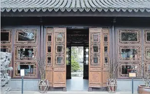  ??  ?? Intricatel­y carved wooden windows and doors of the Hall of Brocade Clouds frame the view of the inner garden. The carvings depict plum, bamboo and pine, known as the Three Friends of Winter. In a traditiona­l Chinese garden, this area was used to meet...