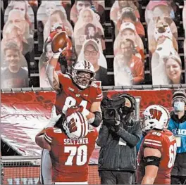  ?? MORRY GASH/AP ?? Wisconsin's Jake Ferguson celebrates a touchdown in front of cardboard cutouts Friday.