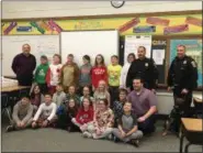  ?? TYLER RIGG — THE NEWS-HERALD ?? Longfellow elementary students pose with Eastlake Police Chief Larry Reik, Officer Mike Ward, K-9 Officer Axel and Mayor Dennis Morley before enjoying a pizza party.