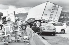  ?? Gina Ferazzi Los Angeles Times ?? A BIG RIG crashed through the center divider on the 60 Freeway in Monterey Park, crushing a car underneath and causing four other autos to collide Tuesday.