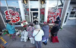  ?? (AP/David Zalubowski) ?? Mourners gather Tuesday outside one of the gunman-targeted tattoo parlors along South Broadway in Denver. Video at arkansason­line.com/1230denver/.