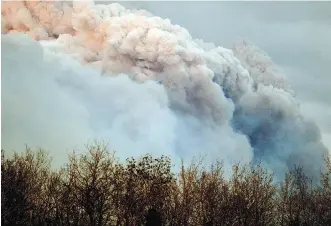  ?? LARRY WONG ?? A pyrocumulu­s cloud thousands of metres tall formed above from the Fort McMurray wildfire on May 4, 2016, as heat from the wildfire created its own weather system.