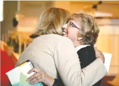  ??  ?? Nurse and Ebola survivor Nancy Writebol, right, embraces Linda McCauley, dean of Emory University’s nursing school, after speaking to nursing students at Emory in Atlanta on Friday. Writebol was the second American to receive treatment at Emory after...
