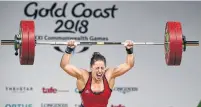  ?? WILLIAM WEST/GETTY IMAGES PHOTOS ?? Canadian weightlift­er Maude Charron hoists and celebrates the winning lift in the 63-kilo category at the Commonweal­th Games on Saturday: “I wanted it very bad.”