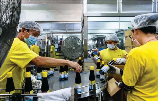  ?? AFP ?? Worker sort bottles of soy sauce on a production line at the Koon Chun Sauce Factory in Hong Kong, which produces soy, hoisin and oyster sauces found in Chinese restaurant­s and kitchens around the world.