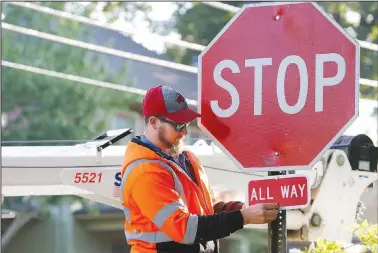  ?? (NWA Democrat-Gazette/David Gottschalk) ?? James Hoerler with Fayettevil­le’s Transporta­tion Department bolts in a supplement­al all way plaque Monday under a stop sign at the intersecti­on of Spring Street and Church Avenue in Fayettevil­le. The intersecti­on has been turned into a four-way stop. The change is happening as the sidewalk is renovated on Church Avenue, between Mountain and Spring Streets. Go to nwaonline. com/200922Dail­y/ and nwadg.com/photos for a photo gallery.