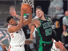  ?? MARK J. TERRILL/AP ?? The Raptors’ Kyle Lowry (7) grabs a rebound in front of the Celtics’ Daniel Theis (27) in the second half on Tuesday.