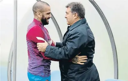  ?? FCBARCELON­A ?? Dani Alves abraçant el president Joan Laporta a l’entrenamen­t del Barcelona ahir