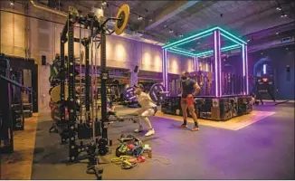  ??  ?? DOWNTOWN’S John Reed gym, with a neon-lighted DJ booth at its center, opened in March.