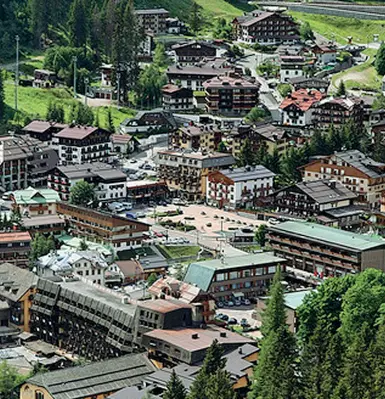  ??  ?? Nel mirino Sopra Madonna di Campiglio, regno delle seconde case. A fianco, turisti sulle piste da sci