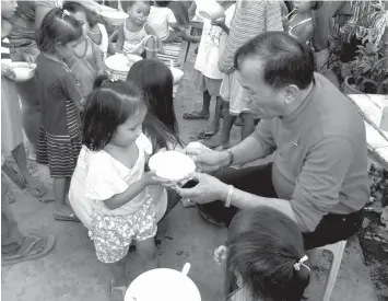  ??  ?? Talisay City Mayor Johnny De los Reyes leads a feeding program.